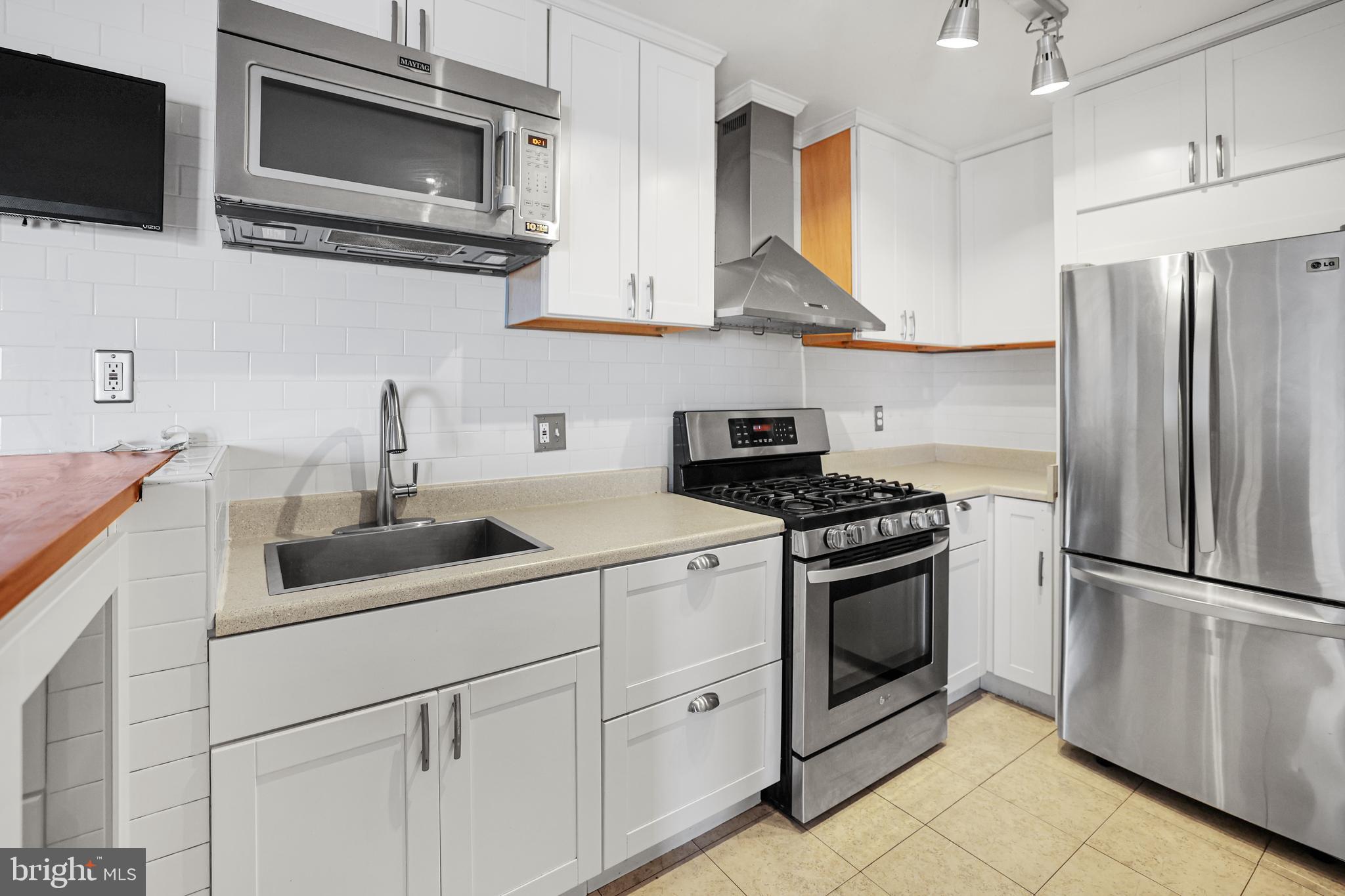 2634 Bowen Road Southeast, Unit 404 Washington, DC 20020 - Photo 6 of 15 a kitchen with stainless steel appliances granite countertop a sink stove and microwave