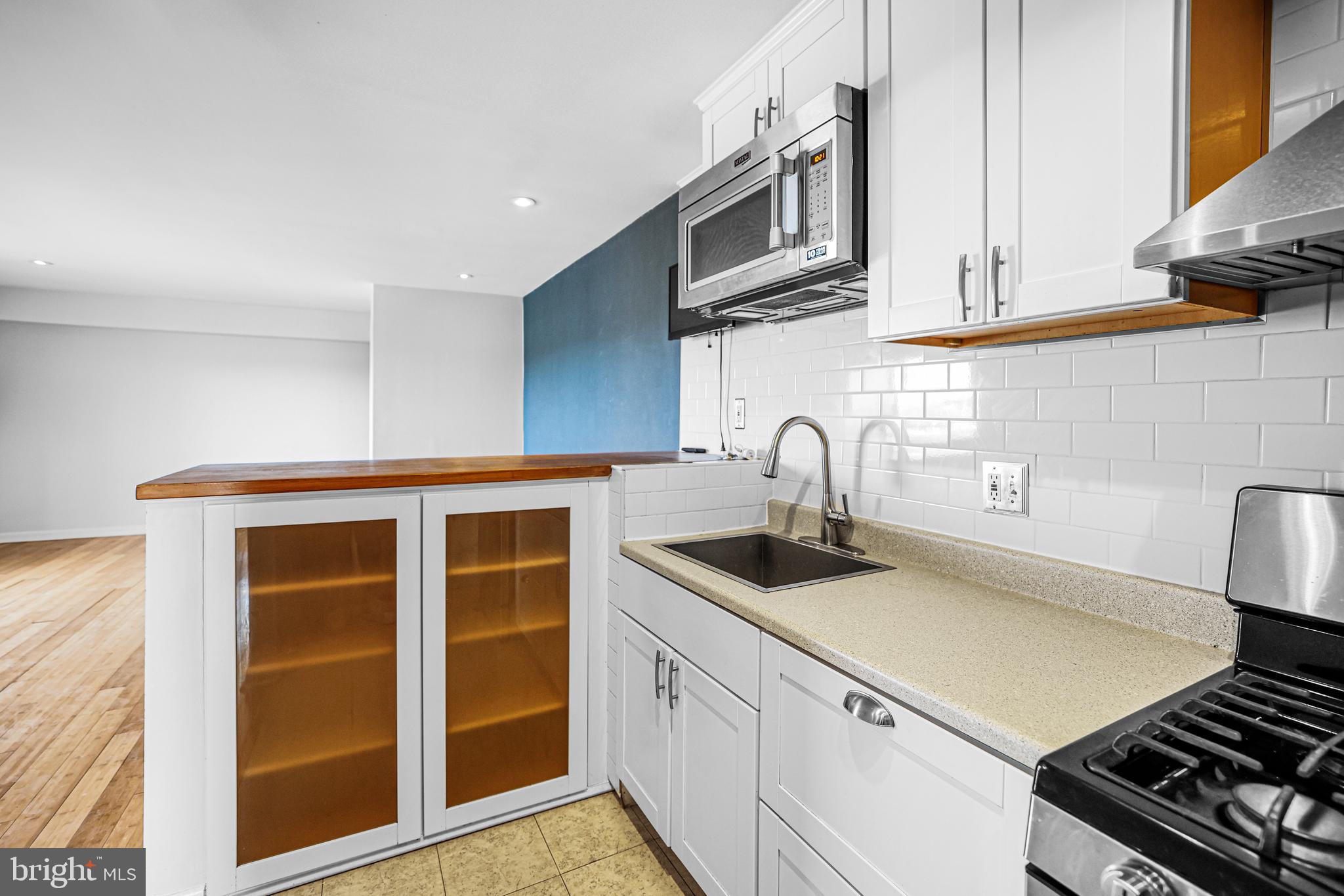 2634 Bowen Road Southeast, Unit 404 Washington, DC 20020 - Photo 7 of 15 a kitchen with stainless steel appliances a sink a stove and cabinets