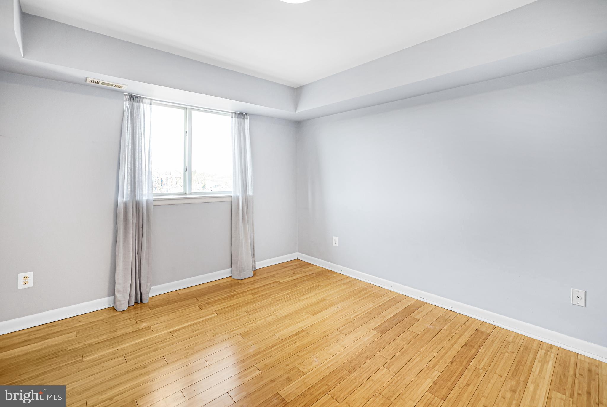 2634 Bowen Road Southeast, Unit 404 Washington, DC 20020 - Photo 8 of 15 an empty room with wooden floor and windows