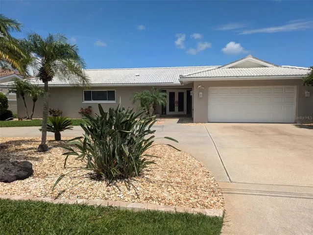 a view of a house with a yard and potted plants