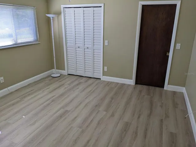 an empty room with wooden floor and closet