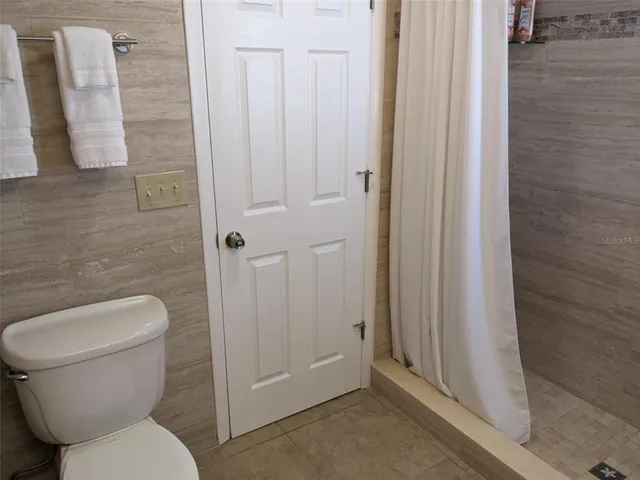 a bathroom with a toilet and a shower