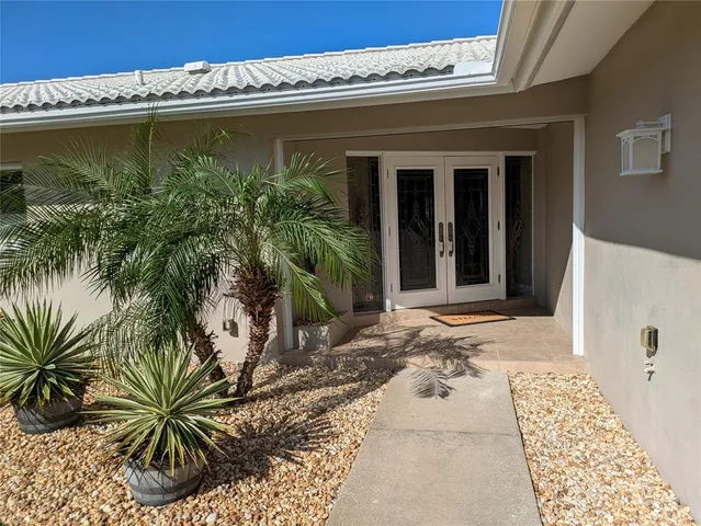 a view of a entryway door with potted plants