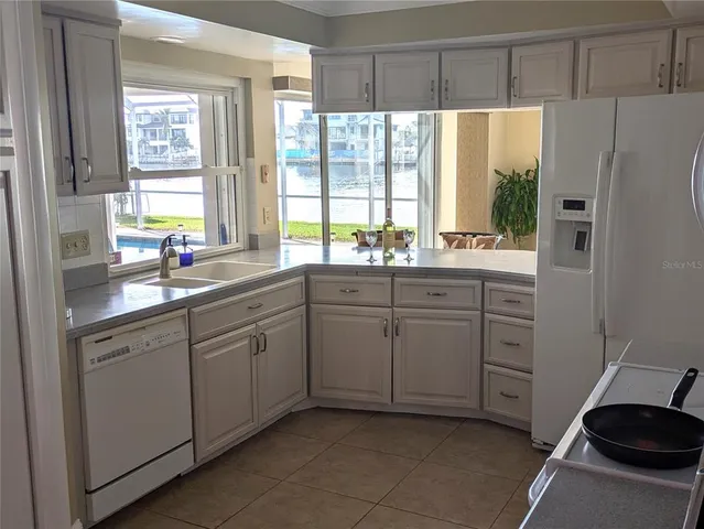 a kitchen with stainless steel appliances a refrigerator sink and cabinets
