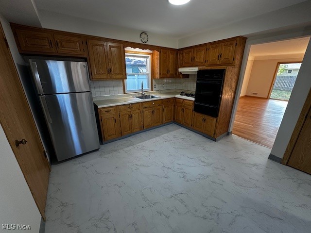 8375 Royal Ridge Drive Parma, OH 44129 - Photo 2 of 12 Kitchen with backsplash, freestanding refrigerator, light countertops, brown cabinets, and oven