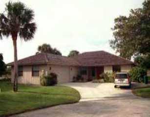10344 Southeast Skipjack Circle Hobe Sound, FL 33455 - Photo 1 of 1 a front view of a house with a garden and trees