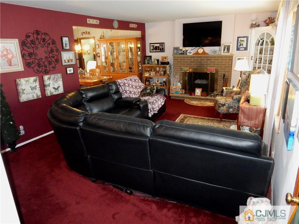 107 West Hill Road Colonia, NJ 07067 - Photo 3 of 16 a living room with furniture a flat screen tv and a fireplace