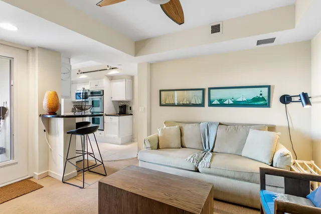 a living room with furniture and kitchen view