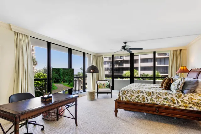 a bedroom with a bed and large windows