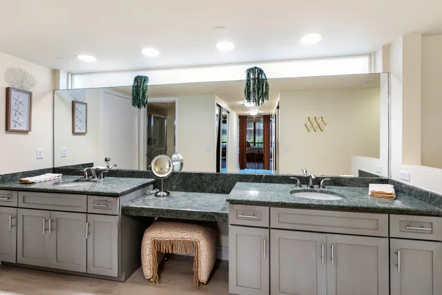 a bathroom with a granite countertop sink a mirror and shower