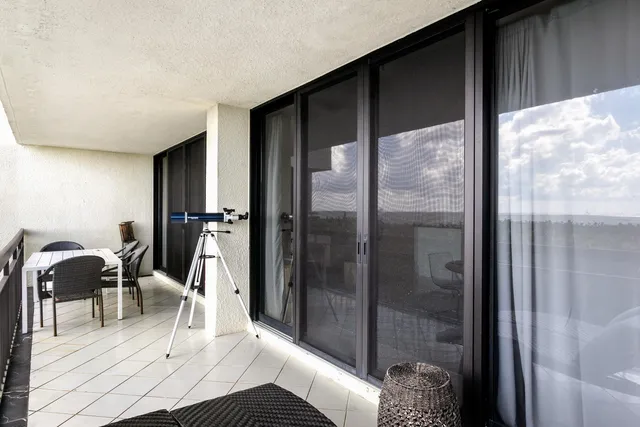 a dining room with furniture and a floor to ceiling window