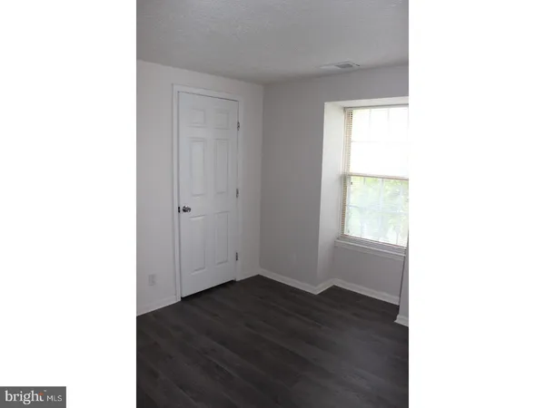 a view of a room with wooden floor and a window