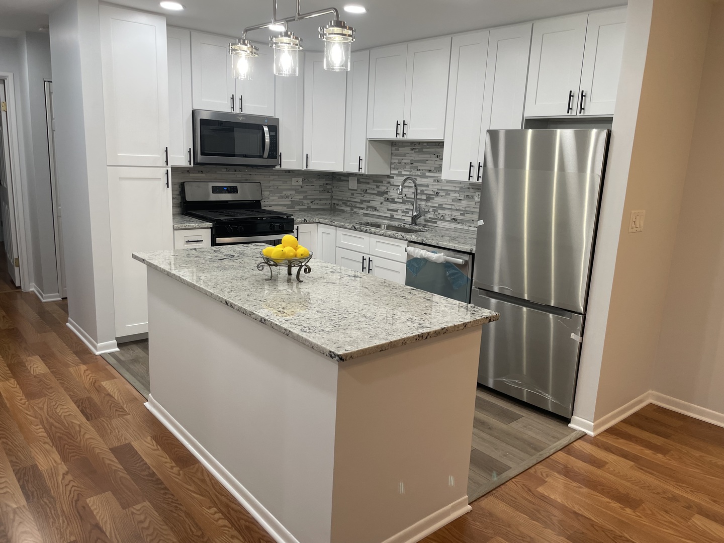 500 74th Street, Unit 102 Downers Grove, IL 60516 - Photo 2 of 21 a kitchen with stainless steel appliances a refrigerator a stove a sink a microwave and wooden cabinets