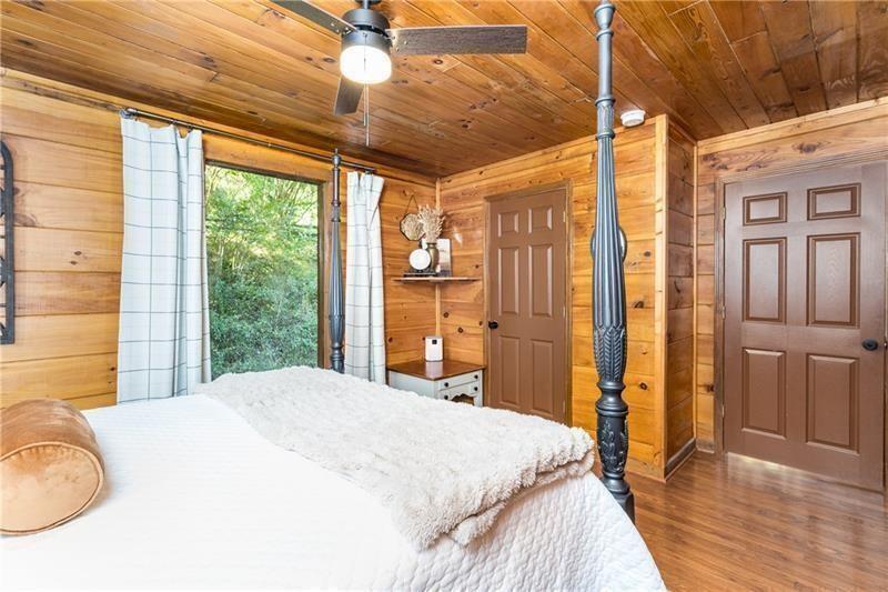 2889 Old Parker Pl Road Ellijay, GA 30536 - Photo 29 of 59 a bedroom with a large bed and a chandelier