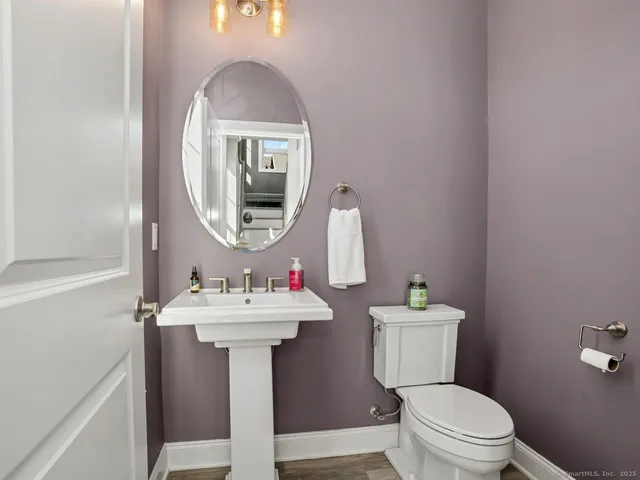 a bathroom with a sink mirror and toilet
