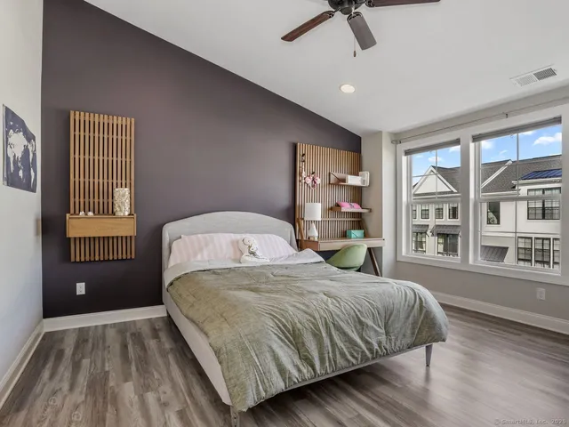 a bedroom with a bed wooden floor and window