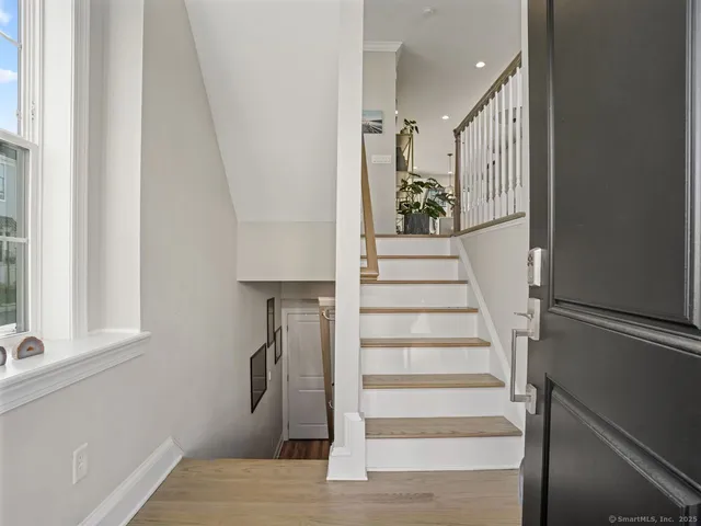 a view of entryway and hall with wooden floor