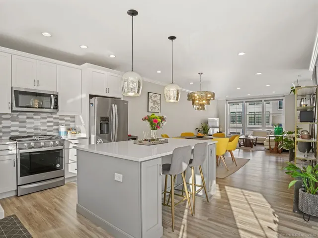 a open kitchen with stainless steel appliances granite countertop a stove top oven a sink a counter top space and cabinets