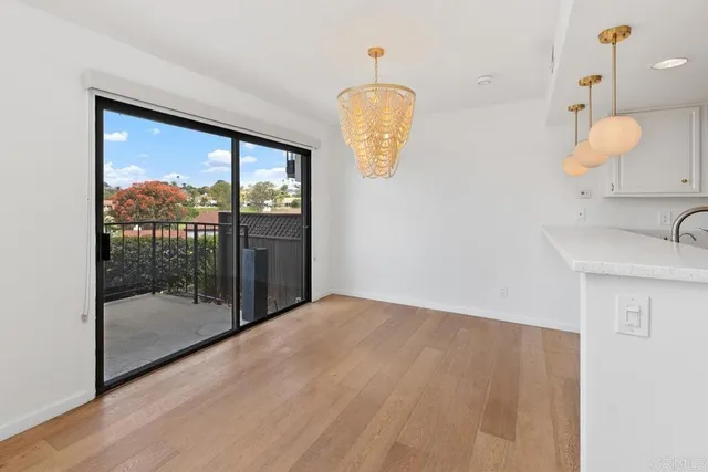 a view of a room with wooden floor and a ceiling fan
