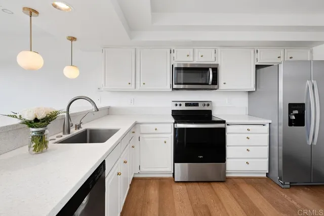 a kitchen with a white cabinets and stainless steel appliances