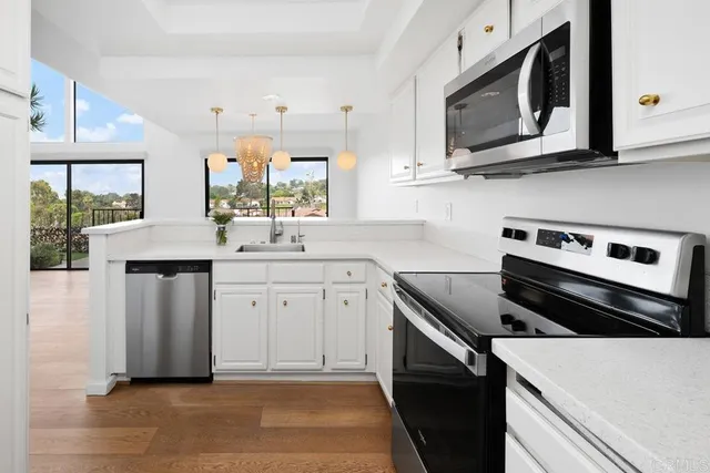 a kitchen with stainless steel appliances a stove microwave and sink