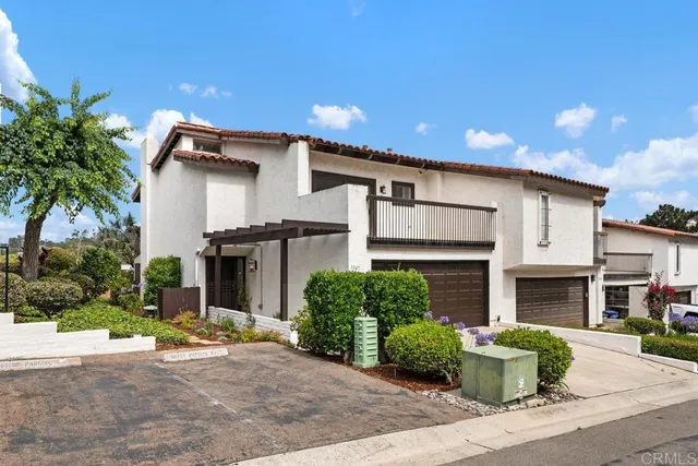 a front view of a house with a yard and potted plants