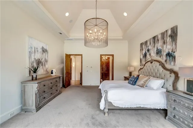 a spacious bedroom with a bed and a chandelier