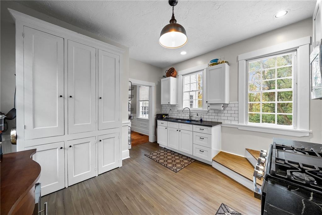 755 South Main Street Washington, PA 15301 - Photo 15 of 44 a kitchen with stainless steel appliances granite countertop a stove a sink and white cabinets with wooden floor
