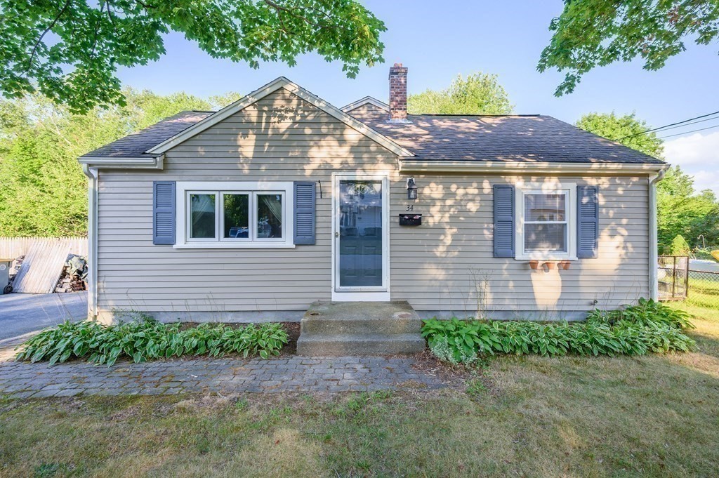 a front view of a house with a yard and potted plants