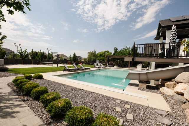 924 Country Lane Farmington, UT 84025 - Photo 87 of 91 Rectangular swimming pool with integrated slide, surrounded by a concrete patio and grey gravel landscaping