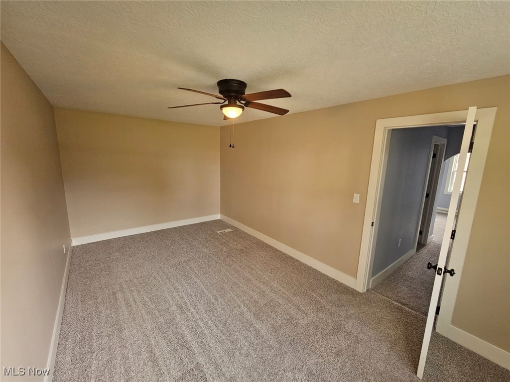 5961 State Rte 213 Toronto, OH 43964 - Photo 12 of 15 Carpeted empty room with ceiling fan and a textured ceiling