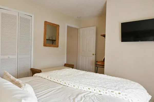 a bedroom with a bed and a flat screen tv