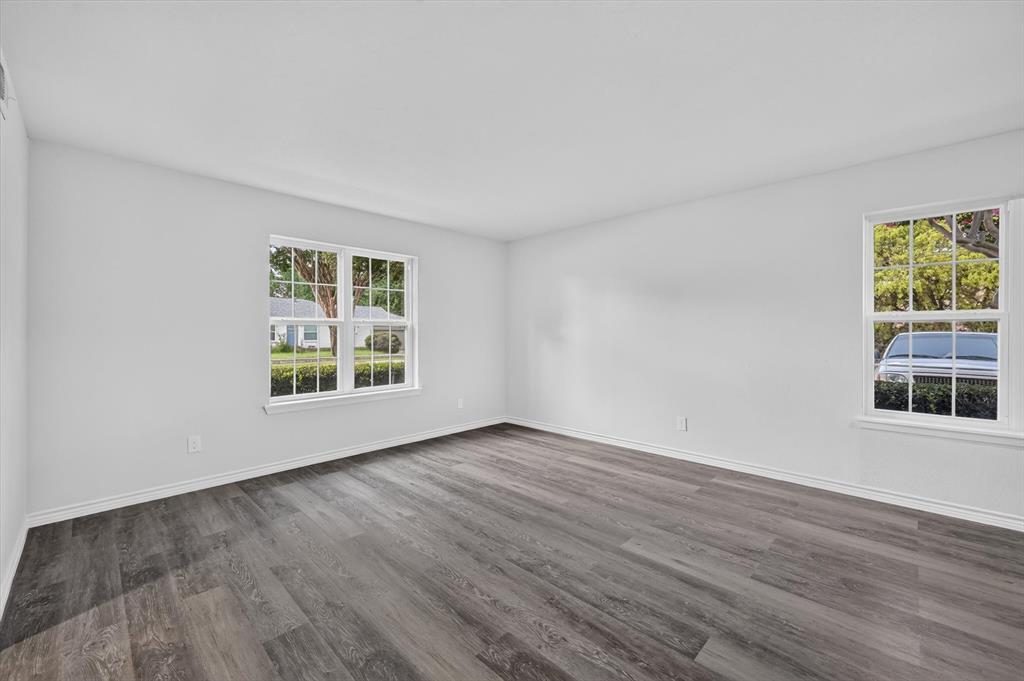 1801 East Grauwyler Road, Unit 101 Irving, TX 75061 - Photo 31 of 39 an empty room with wooden floor and windows