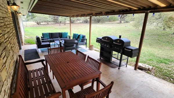 a living room with stainless steel appliances furniture and wooden floor