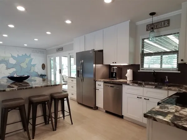 a kitchen with stainless steel appliances granite countertop a stove a sink and a microwave