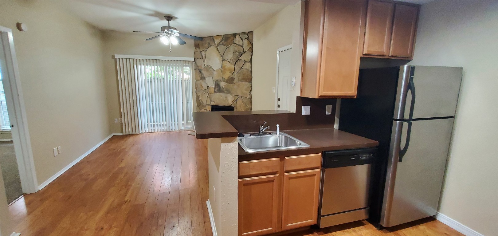 114 East 31st Street, Unit 114 Austin, TX 78705 - Photo 5 of 11 a kitchen with stainless steel appliances granite countertop a refrigerator a sink and a stove with wooden floor