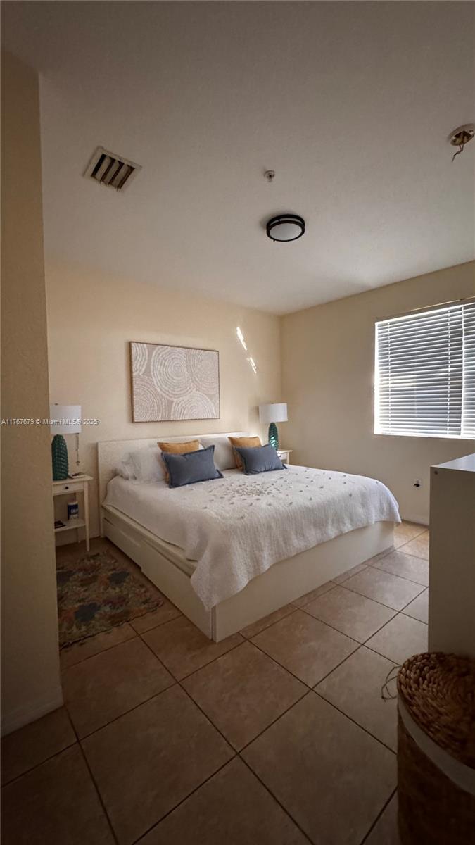 1033 Southwest 144th Avenue, Unit 2705 Pembroke Pines, FL 33027 - Photo 20 of 28 a bedroom with a bed and with windows