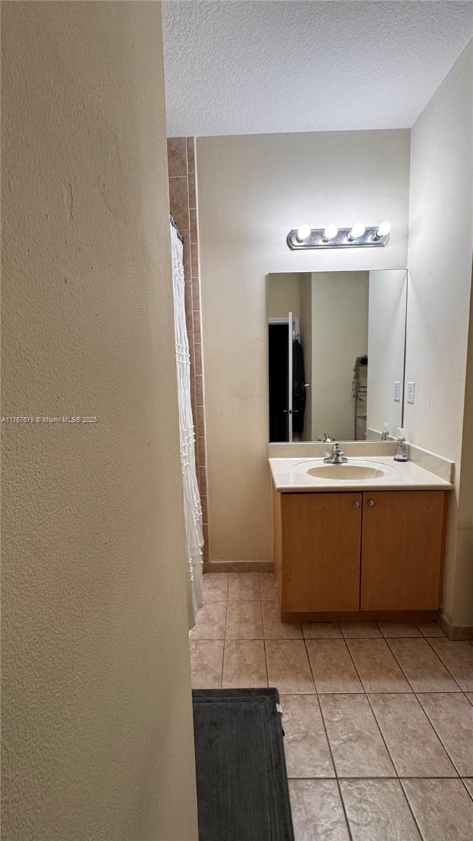 1033 Southwest 144th Avenue, Unit 2705 Pembroke Pines, FL 33027 - Photo 23 of 28 a bathroom with a sink a mirror and a bathtub