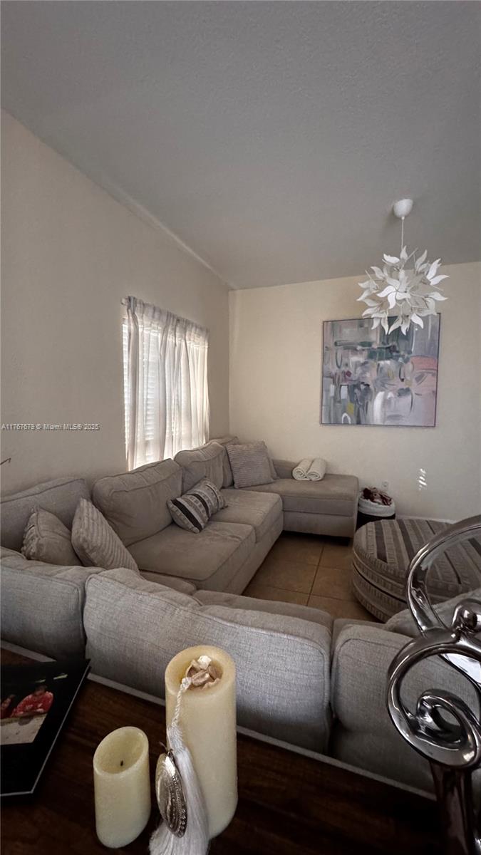 1033 Southwest 144th Avenue, Unit 2705 Pembroke Pines, FL 33027 - Photo 5 of 28 a living room with furniture and a chandelier