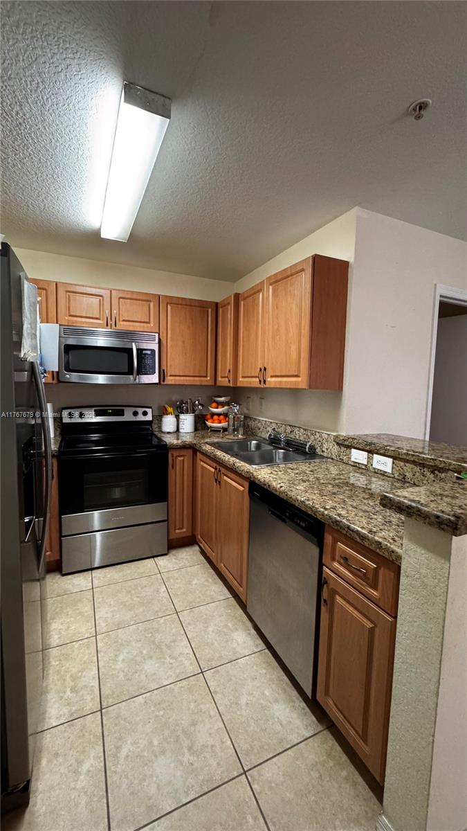 1033 Southwest 144th Avenue, Unit 2705 Pembroke Pines, FL 33027 - Photo 9 of 28 a kitchen with stainless steel appliances granite countertop a stove a sink and a microwave