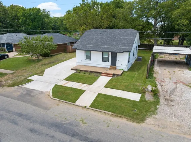a aerial view of a house with swimming pool and a yard