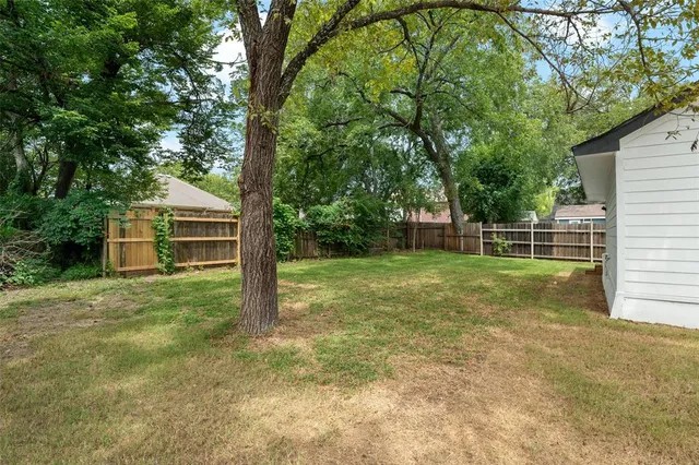 a view of a house with backyard and trees
