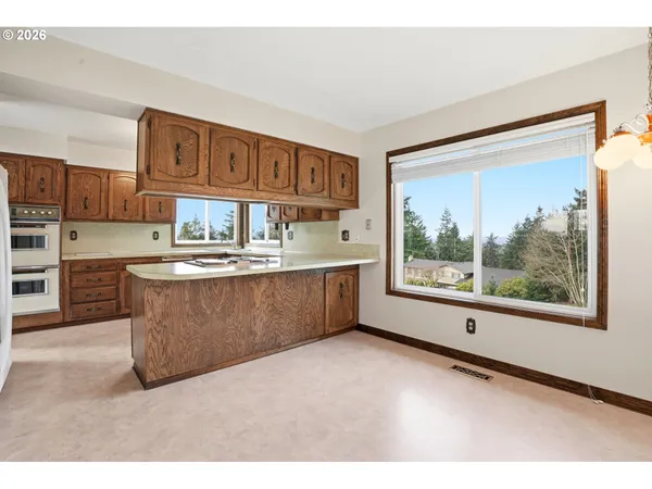 a kitchen with kitchen island a stove a sink and a refrigerator with wooden floor