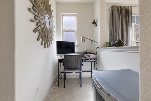 a view of a workspace with furniture and a window