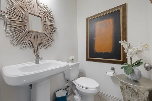 a bathroom with a sink a toilet and a mirror
