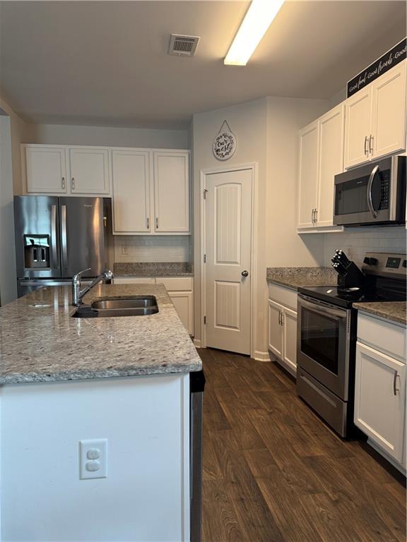 358 Mulberry Road Winder, GA 30680 - Photo 6 of 21 a kitchen with stainless steel appliances granite countertop a sink stove microwave and refrigerator