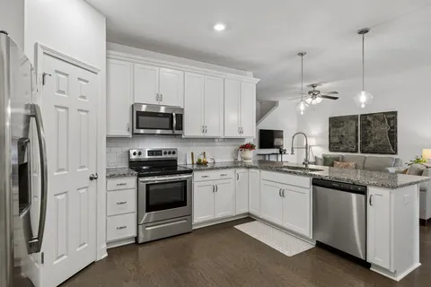 a kitchen with stainless steel appliances granite countertop a stove a sink and a refrigerator