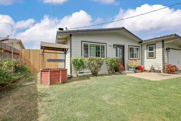 a view of a house with backyard sitting area and garden