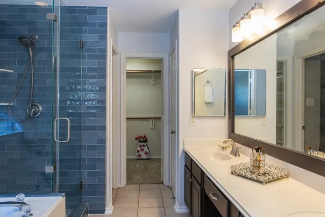 a bathroom with a granite countertop sink a mirror and shower