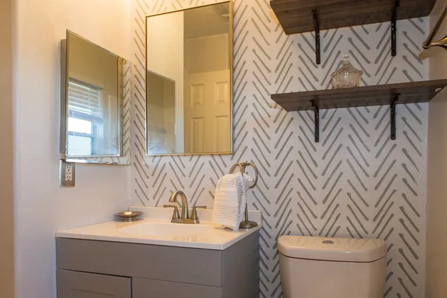 a bathroom with a sink a toilet and a mirror